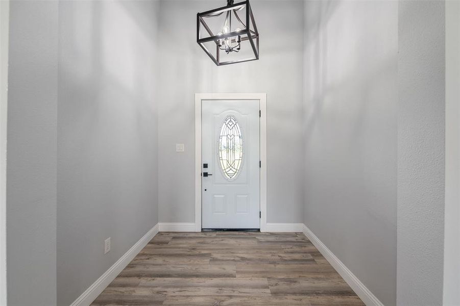 Entryway featuring a chandelier and wood finished floors Entryway featuring a chandelier and wood finished floors
