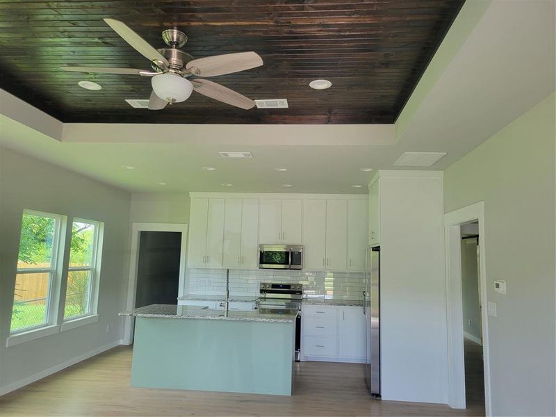 Kitchen area featuring a wood-finish tray ceiling, recessed lighting, and a modern ceiling fan