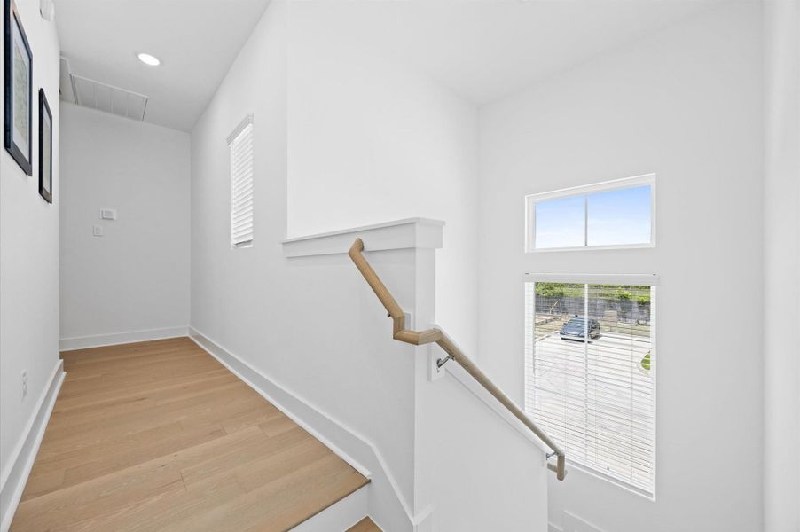 Beautifull staircase with rich hardwood steps and wooden railing leads you to the bedrooms. Natural light pours in from the big window located in the stair landing, illuminating the open layout. Beautifull staircase with rich hardwood steps and wooden railing leads you to the bedrooms. Natural light pours in from the big window located in the stair landing, illuminating the open layout.