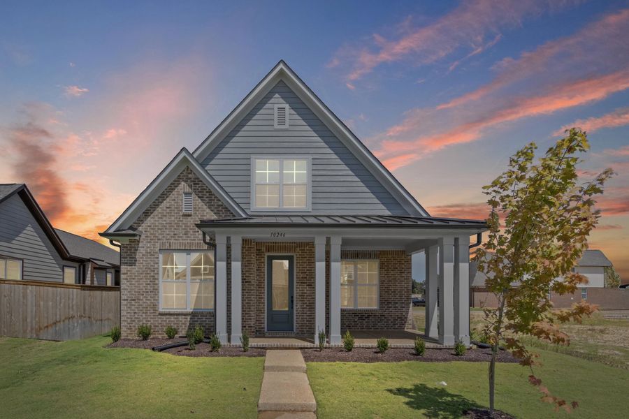 View of front of home with brick siding, a standing seam roof, a porch, and a metal roof View of front of home with brick siding, a standing seam roof, a porch, and a metal roof