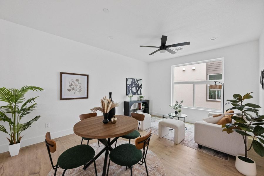 Open-concept living area featuring light wood-finish flooring, recessed ceiling lighting, and a modern ceiling fan
