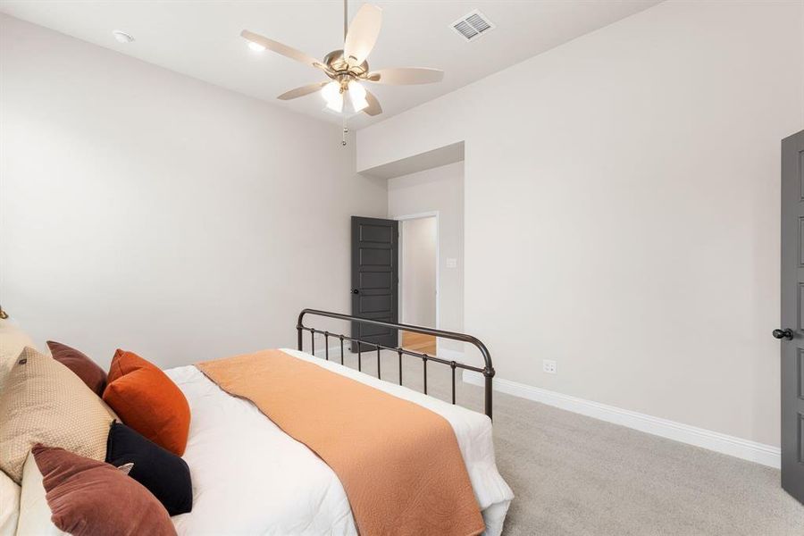 Carpeted bedroom featuring ceiling fan