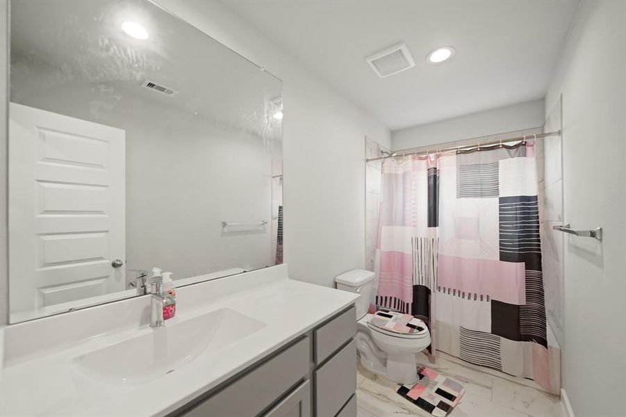 This secondary bath also features a spacious dual vanity, making busy mornings a breeze for the whole family.