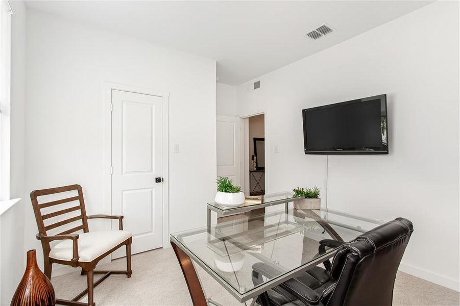 This room features light-colored carpeting and white walls, creating a bright atmosphere