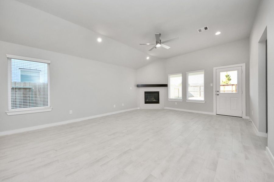 Family room flooded with natural light through the expansive windows. Sample photo of completed home with similar floor plan. Actual colors and selections may vary.