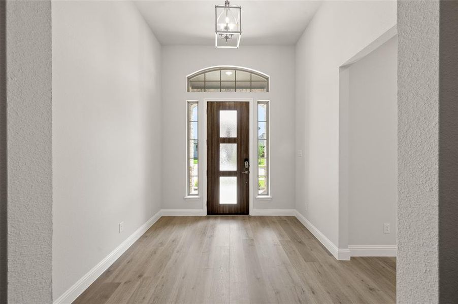 Foyer with light wood-type flooring and baseboards