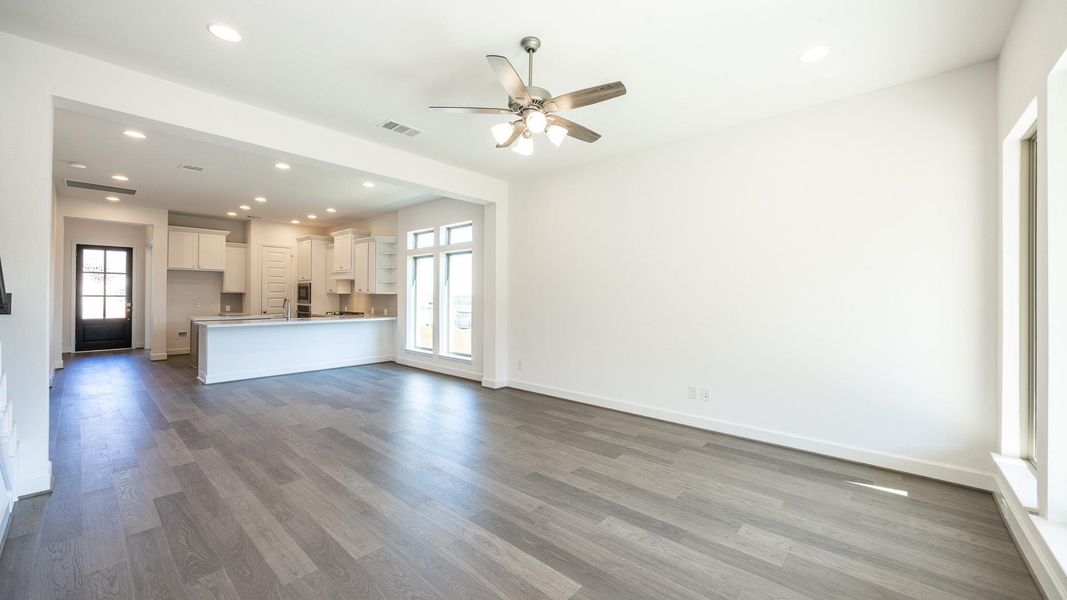 Unfurnished living room with recessed lighting, healthy amount of natural light, dark wood finished floors, and ceiling fan Unfurnished living room with recessed lighting, healthy amount of natural light, dark wood finished floors, and ceiling fan
