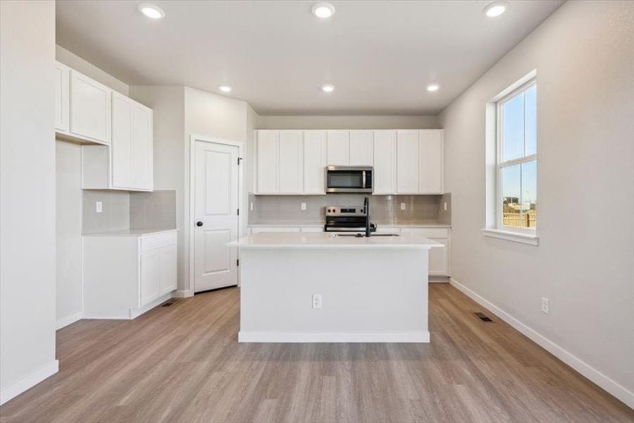 A kitchen with white cabinets.
