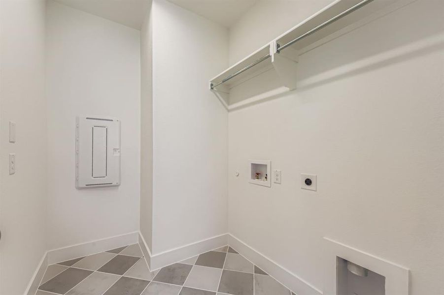 Washroom with hookup for an electric dryer, hookup for a washing machine, and light tile patterned flooring Washroom with hookup for an electric dryer, hookup for a washing machine, and light tile patterned flooring