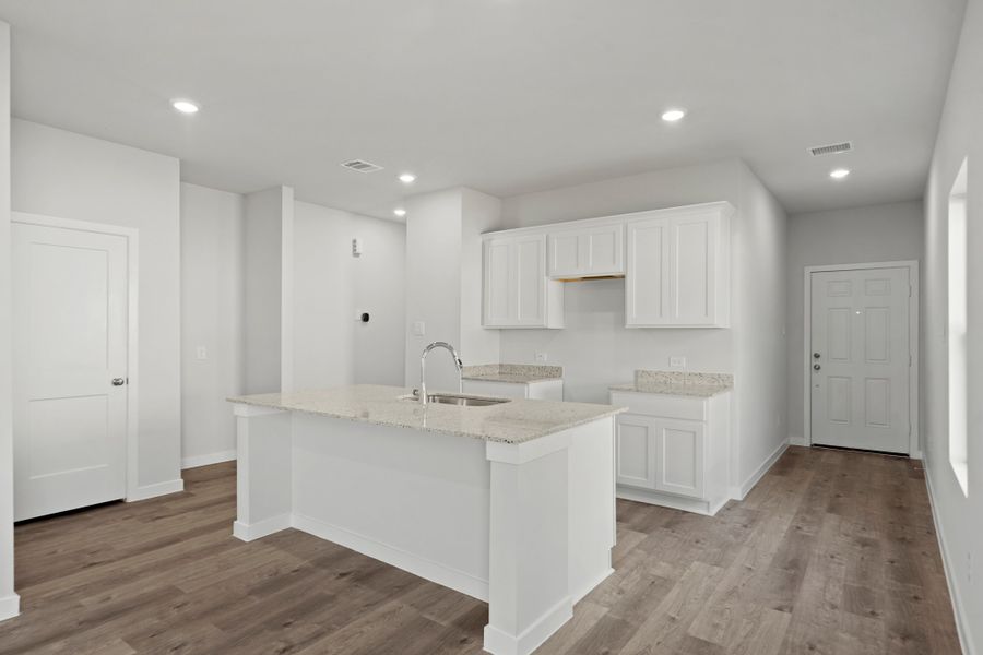 A kitchen with white cabinets.