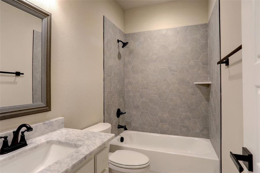 Full bathroom featuring vanity, toilet, and tiled shower / bath combo