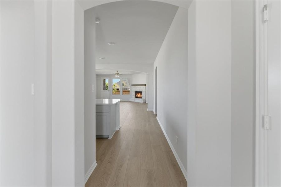 Hall with light wood finished floors and arched walkways