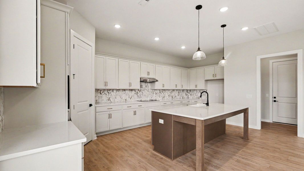 Huge kitchen with quartz countertops and accent backsplash, with a corner pantry and tons of workspace