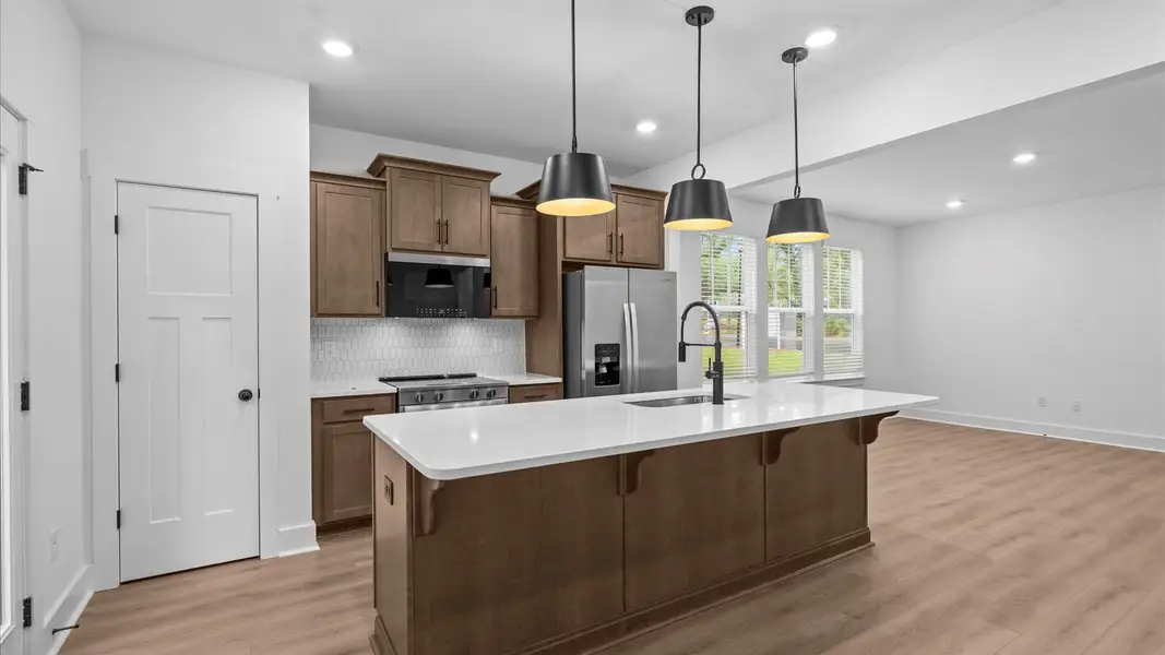Exclusive DRB Homes kitchen with a 9-foot island, elevated finishes, and pendant lighting in a prime location Exclusive DRB Homes kitchen with a 9-foot island, elevated finishes, and pendant lighting in a prime location