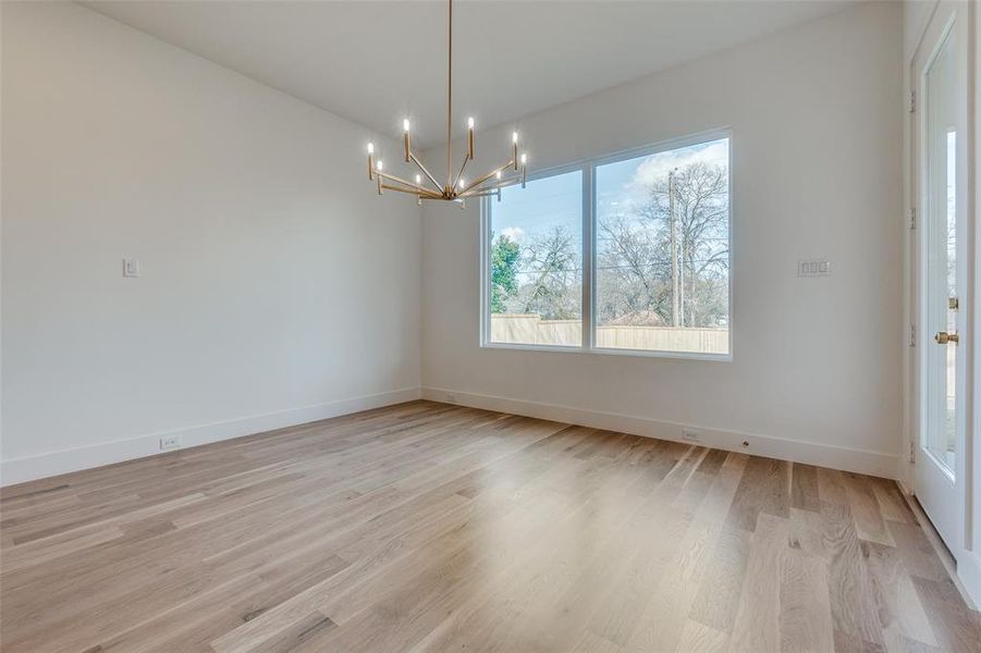 Unfurnished dining area with light hardwood / wood-style floors and a notable chandelier