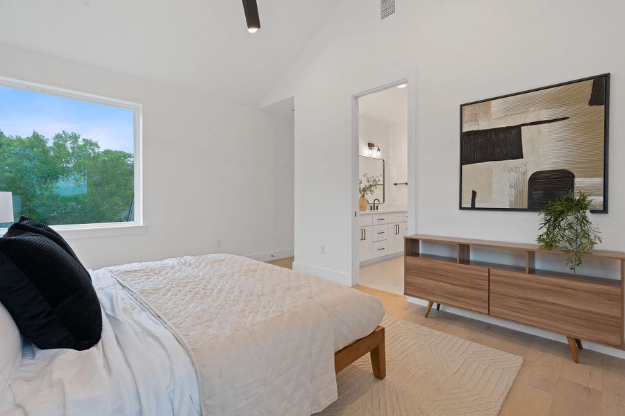 Bedroom with lofted ceiling, light wood-type flooring, ensuite bathroom, and ceiling fan Bedroom with lofted ceiling, light wood-type flooring, ensuite bathroom, and ceiling fan