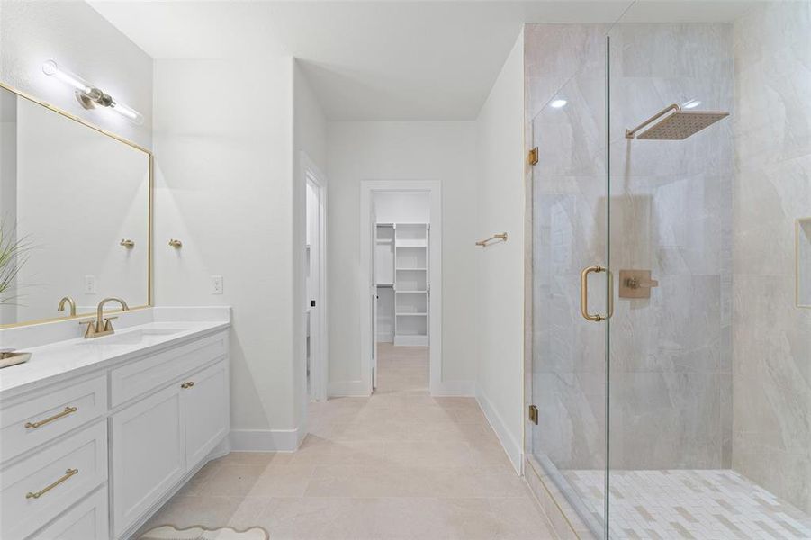 Bathroom with a stall shower, vanity, a spacious closet, and tile patterned floors Bathroom with a stall shower, vanity, a spacious closet, and tile patterned floors