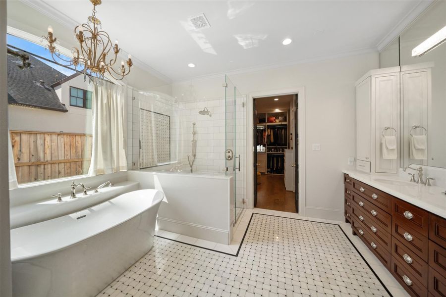 The primary bathroom features elegant marble floors, a spacious walk-in shower, a freestanding soaking tub, and dual vanities.  Abundant natural light and high-end finishes.