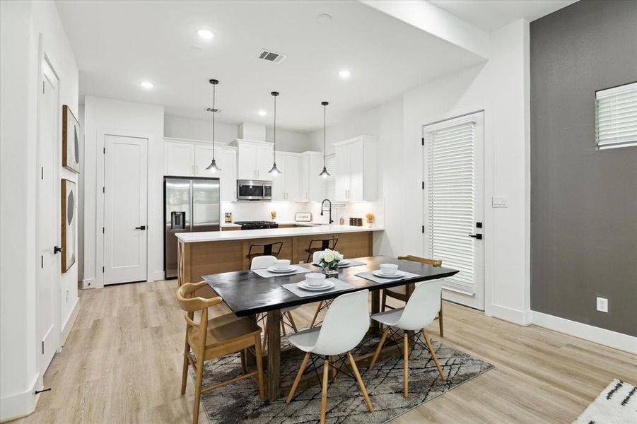 Alternate view of the open-concept kitchen and dining area. The two doors on the left lead to well-designed pantry spaces: one opens to a mini-pantry ideal for spices and condiments, while the other offers added depth ideal for storage