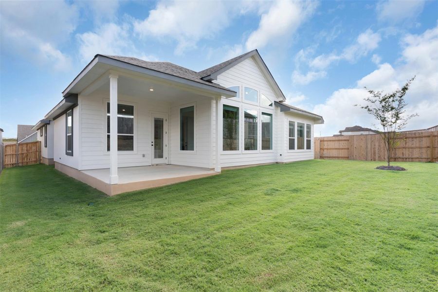 Back of property with a fenced backyard and a patio