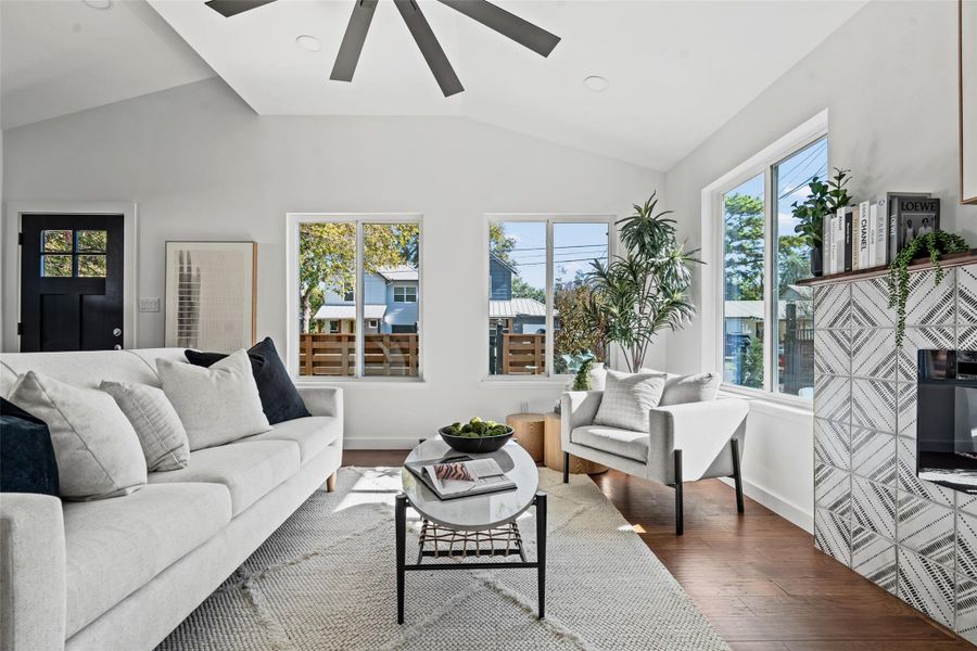 Living room featuring wood finished floors, lofted ceiling, ceiling fan, and recessed lighting