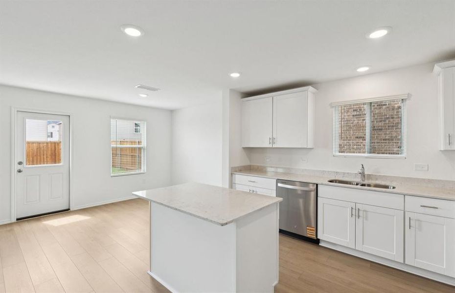 Large island overlooking gathering room and dining areas