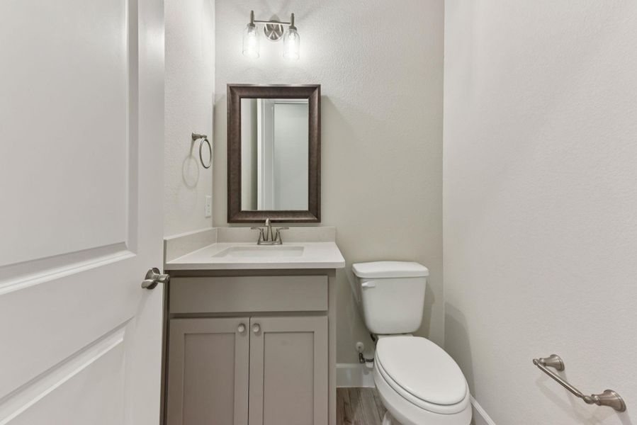 Half bath featuring vanity and toilet