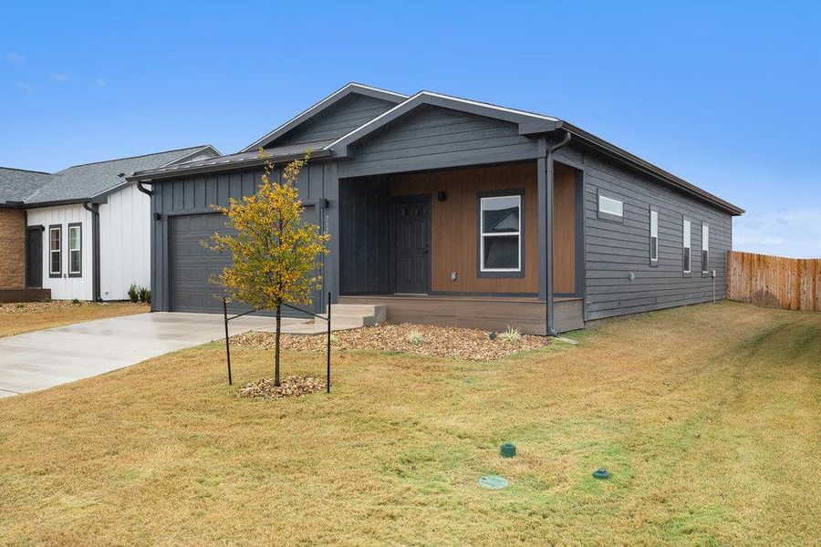 View of front of property with a porch, driveway, and an attached garage