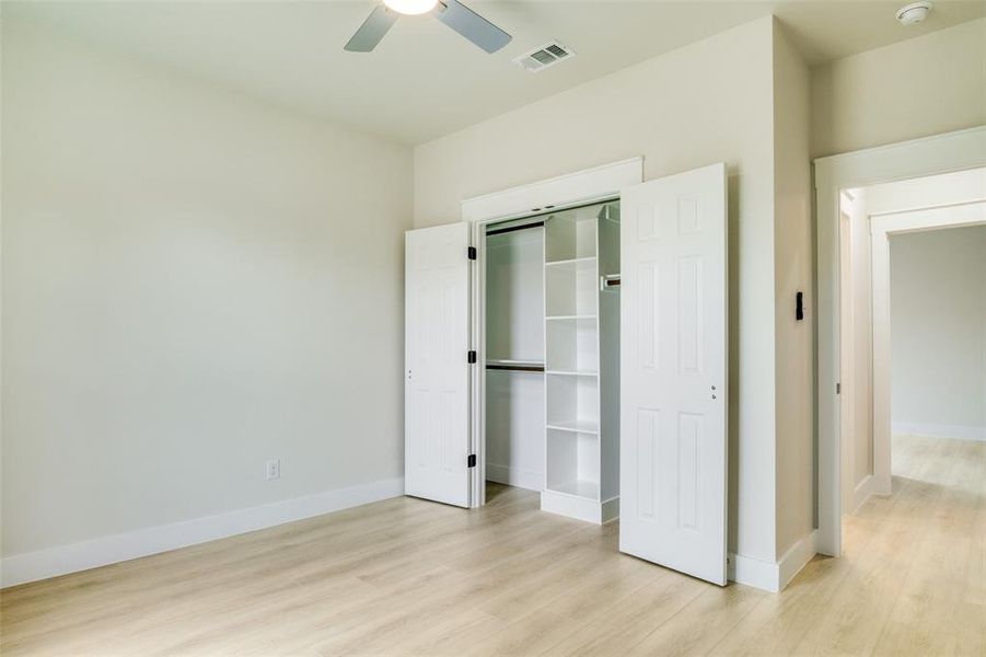 Unfurnished bedroom featuring baseboards, a closet, light wood finished floors, and visible vents