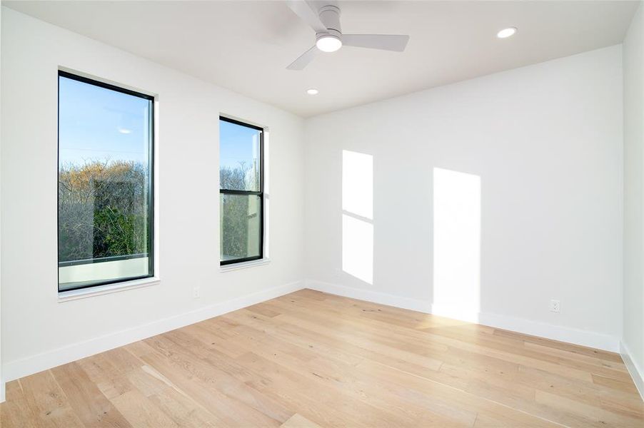 Unfurnished room featuring ceiling fan, plenty of natural light, and light hardwood / wood-style flooring