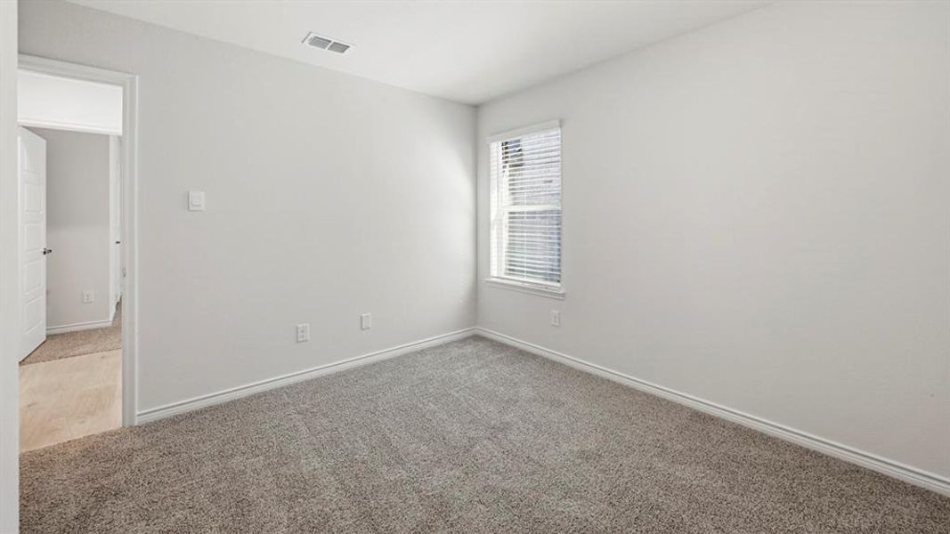 Spare room featuring carpet floors and baseboards