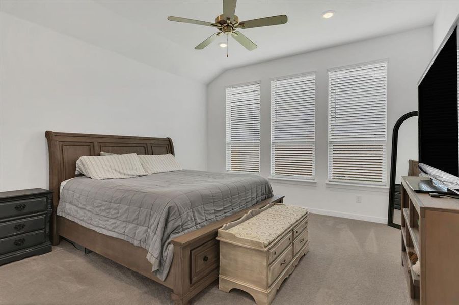 Carpeted bedroom featuring ceiling fan, vaulted ceiling, and recessed lighting