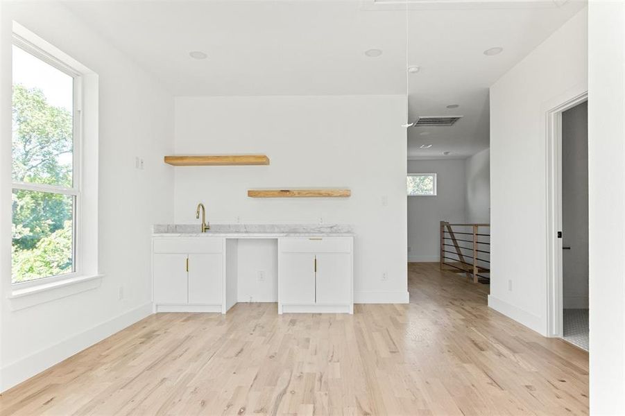 Unfurnished living room featuring a healthy amount of sunlight and light hardwood / wood-style floors