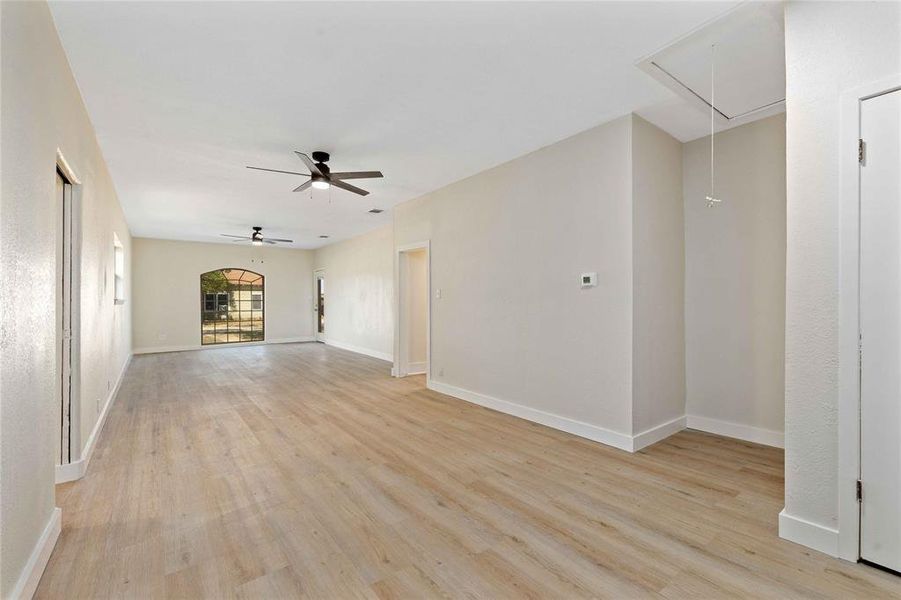 Unfurnished living room featuring attic access and light wood finished floors Unfurnished living room featuring attic access and light wood finished floors