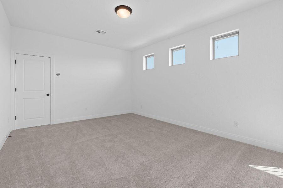 Unfurnished room featuring light carpet and plenty of natural light