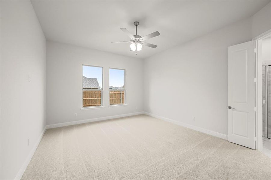 Spare room featuring ceiling fan and light colored carpet