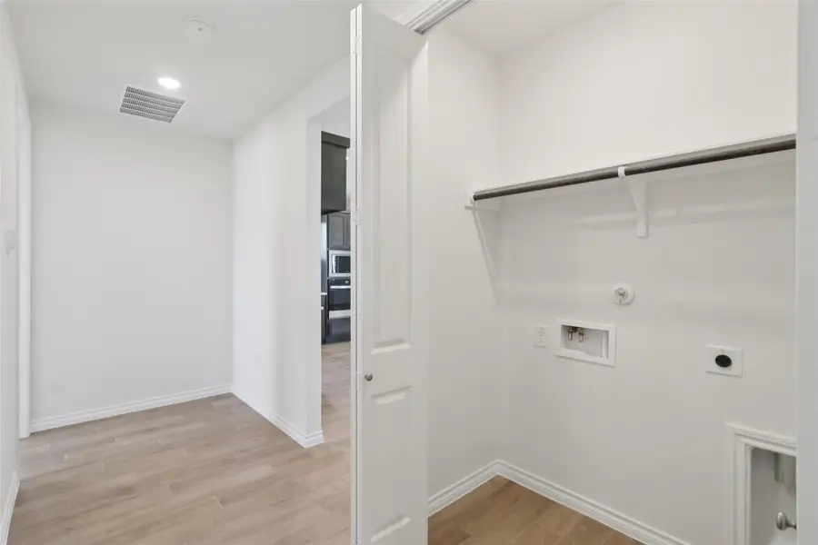 Washroom with hookup for a gas dryer, light wood-type flooring, hookup for an electric dryer, and washer hookup