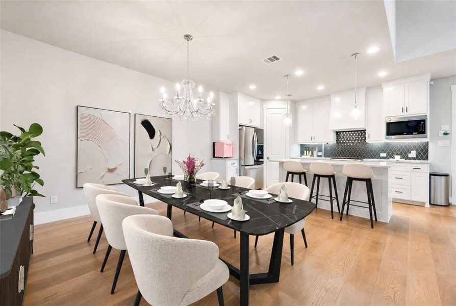 Open-concept dining and kitchen space featuring wood-finish flooring
