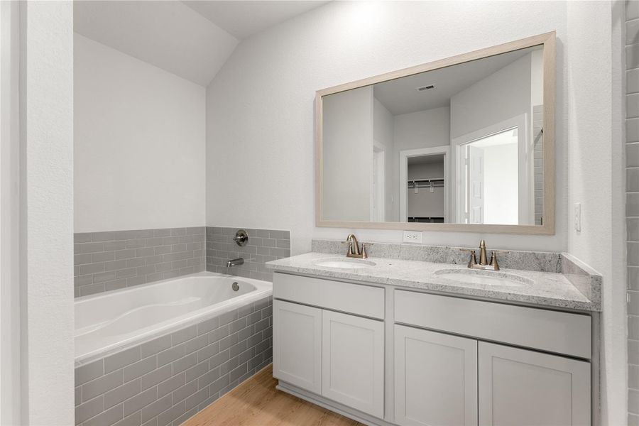 The primary bath features clean, modern finishes with a double-sink vanity, soaking tub, and separate shower. Soft tones and sleek lines create a relaxing, spa-inspired atmosphere. The primary bath features clean, modern finishes with a double-sink vanity, soaking tub, and separate shower. Soft tones and sleek lines create a relaxing, spa-inspired atmosphere.