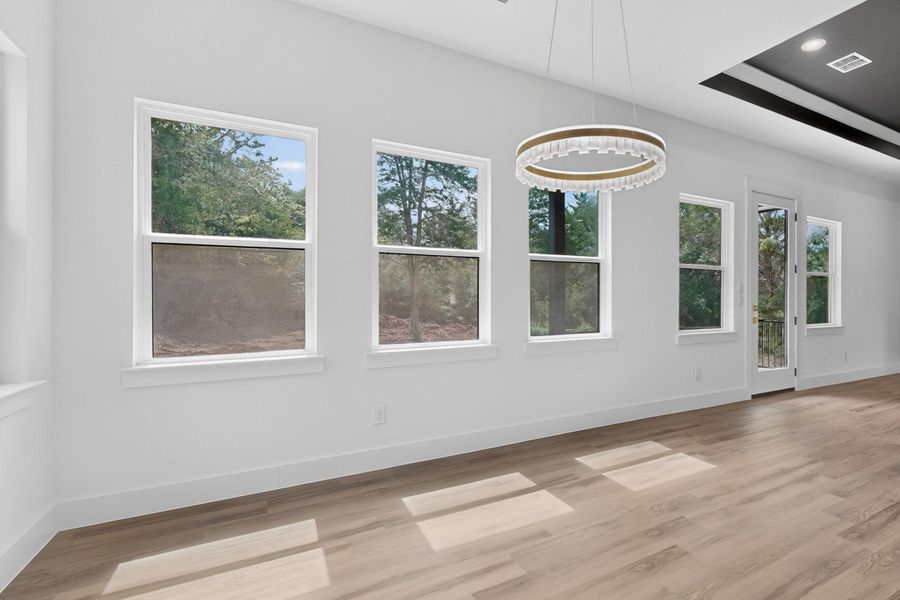 A spacious room with numerous windows and elegant wood flooring awaits.