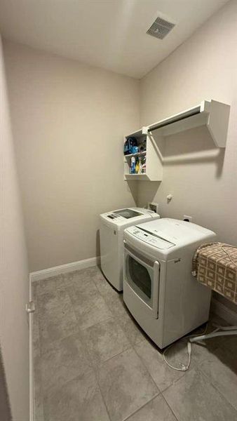 Laundry area with washer and dryer and baseboards