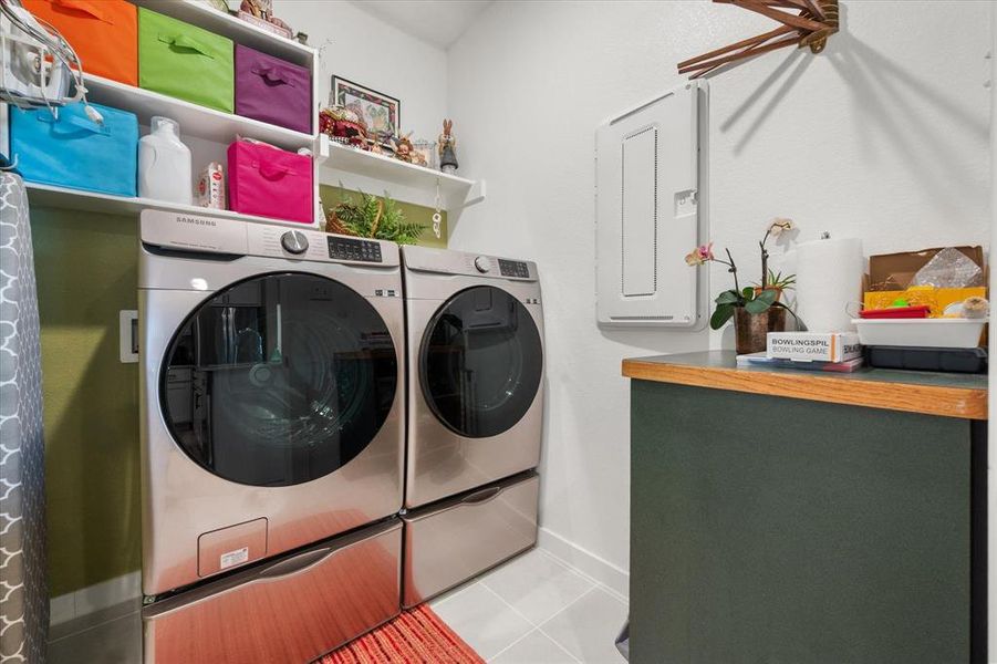 Laundry room featuring electric panel, washing machine and dryer, and tile patterned flooring Laundry room featuring electric panel, washing machine and dryer, and tile patterned flooring