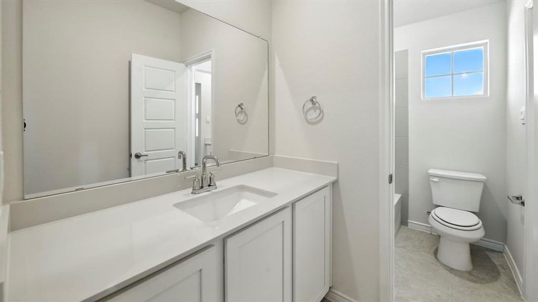 Bathroom featuring vanity, bathing tub / shower combination, and light tile patterned floors Bathroom featuring vanity, bathing tub / shower combination, and light tile patterned floors