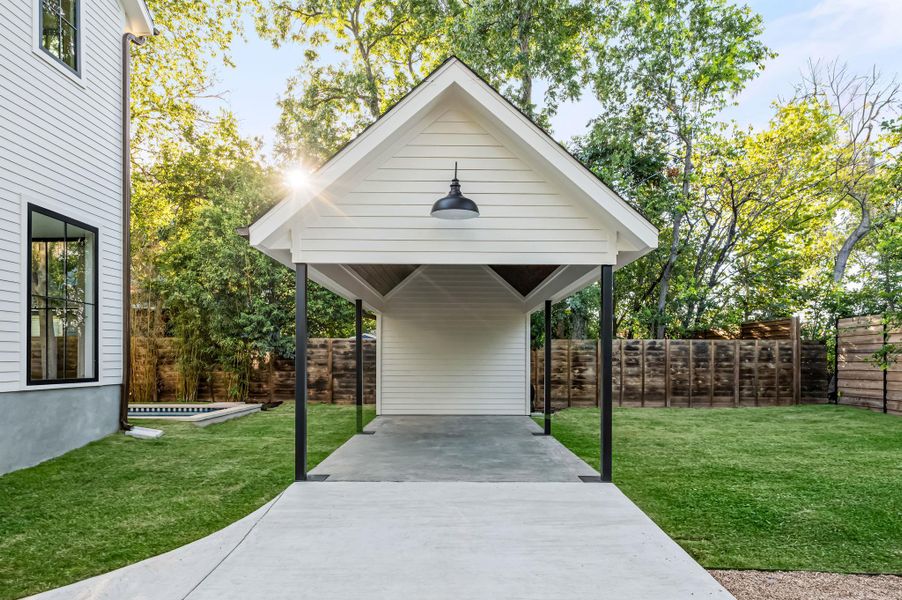 A detached carport structure offers convenient parking and outdoor storage.
