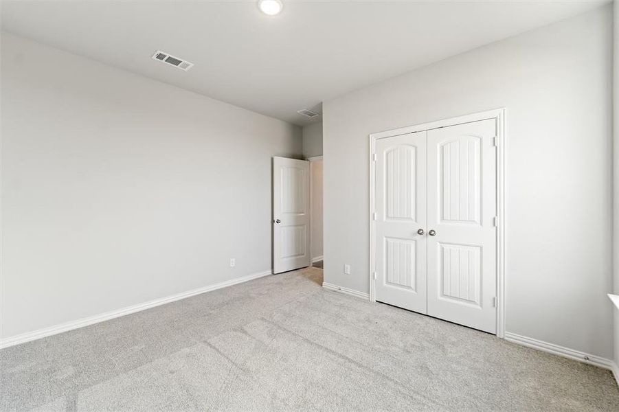 Unfurnished bedroom featuring carpet and a closet