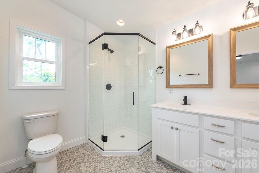 En suite with double vanity and tiles shower