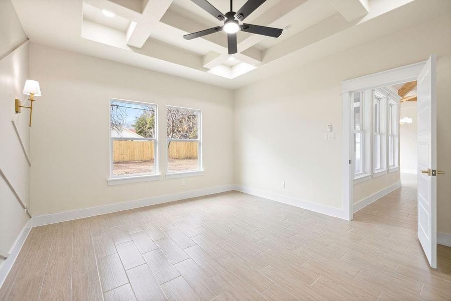 Spare room featuring baseboards, coffered ceiling, a ceiling fan, and light wood-style floors