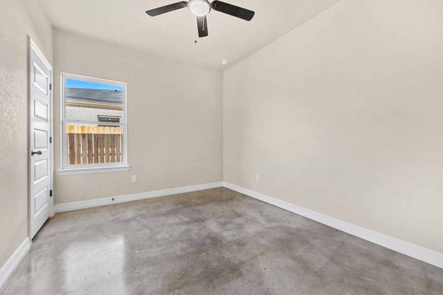 Empty room with concrete flooring and a ceiling fan