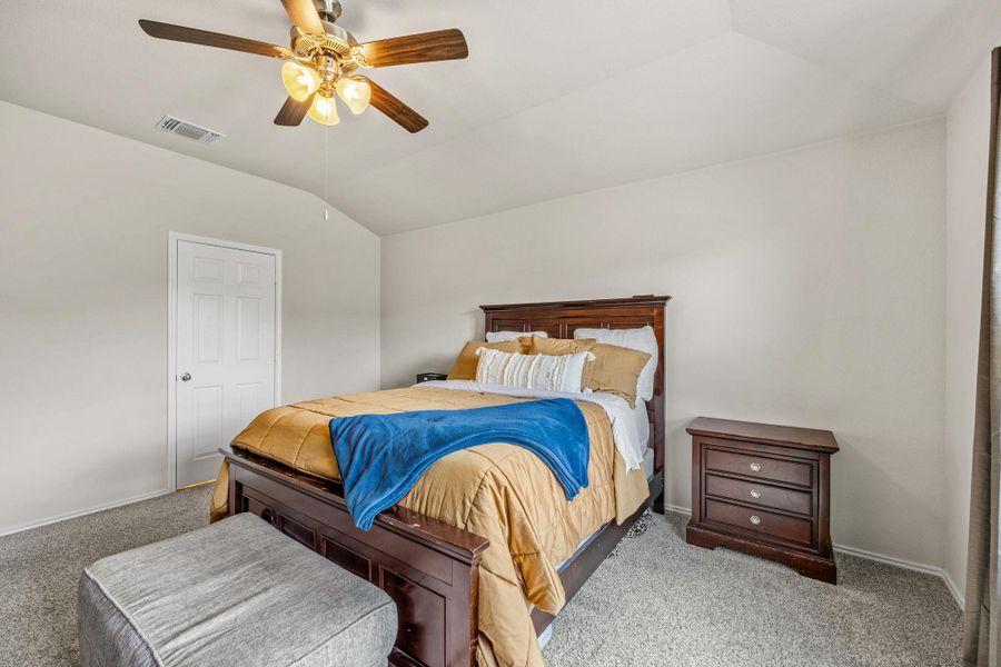 Relax in this tranquil bedroom, featuring soft carpet and a soaring vaulted ceiling.