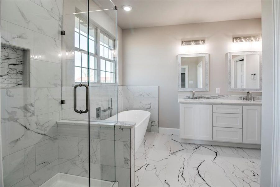 Full bathroom featuring double vanity, light marble finish floors, a soaking tub, a marble finish shower, and recessed lighting